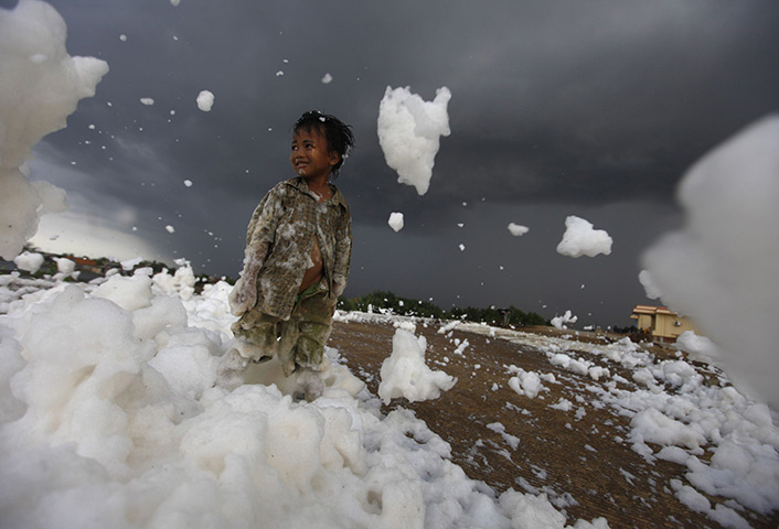 24 hours in pictures: A child stands on foam from a polluted river at the Marunda flood canal