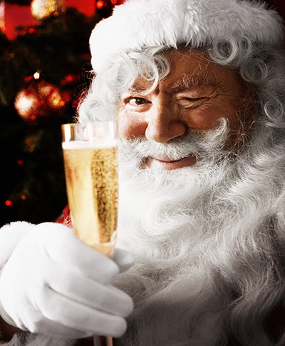 10 best christmas songs: Father Christmas holding glass of champagne