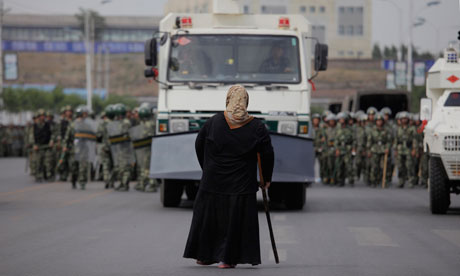 A woman protests against a line of security forces