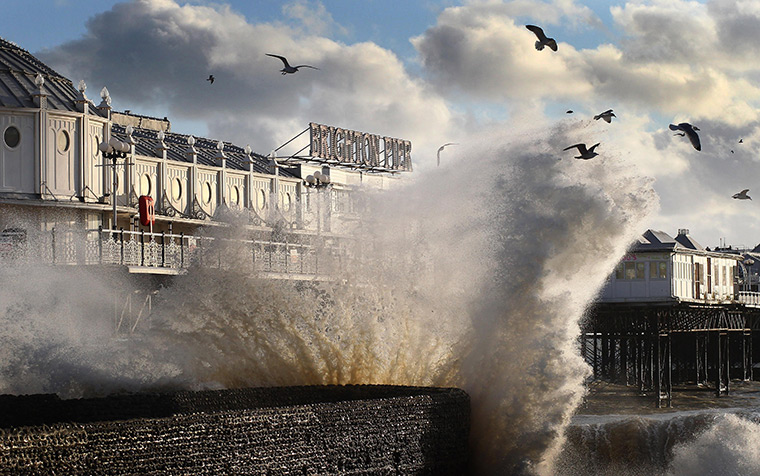 UK Weather: Waves crash on the seafront near Brighton Pier in Brighton, East Sussex