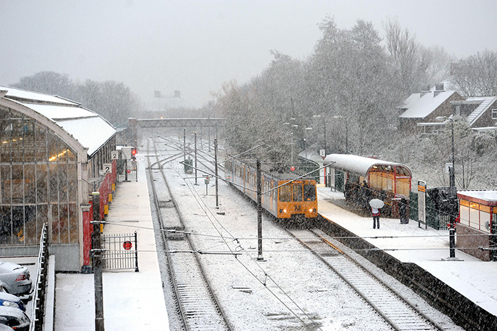 UK Weather: A train pulls in to a snow covered Monkseaton Metro station, North Tyneside