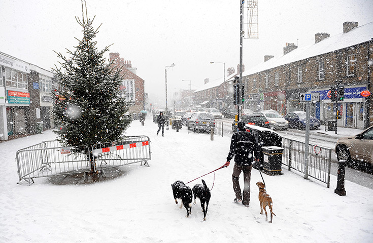 UK Weather: People walk through snow in Main Street, Gateshead