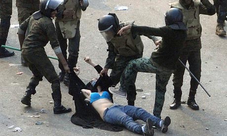 Egyptian army soldiers arrest a female protester during clashes at Tahrir Square, Cairo
