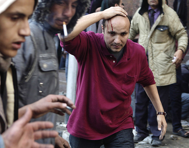 Tahrir Square clashes: A protester's head bleeds from a stone thrown at Tahrir Square