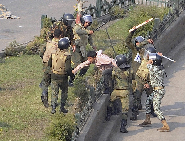 Tahrir Square clashes: Egyptian army soldiers arrest a protester during clashes at Tahrir Square
