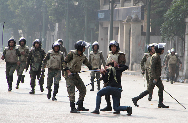 Tahrir Square clashes: Egyptian soldiers arrest a woman during clashes with military polic
