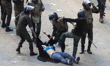 Egyptian army soldiers arrest a female protester during clashes at Tahrir Square, Cairo