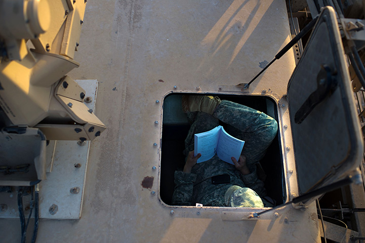 24hours in pictures: A US soldier reads a book as US troops prepare to leave Camp Adde, Iraq