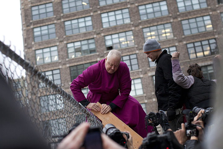 24hours in pictures: Retired Episcopal bishop Packard climbs a ladder during a march in New York