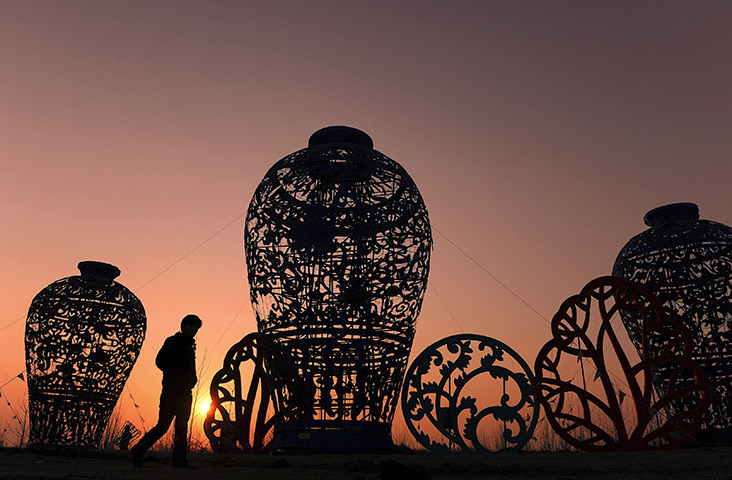 24hours in pictures: A man walks past giant vase-shaped lanterns, China