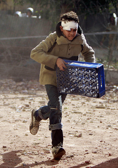 Cairo clashes: A child protester runs during clashes with army soldiers near tahrir square