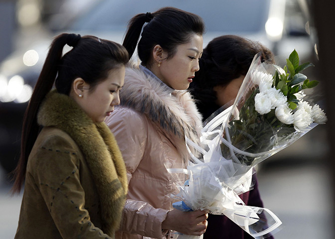 Reaction to Kim Jong il: A woman holding flowers arrives at the North Korean embassy in Beijing