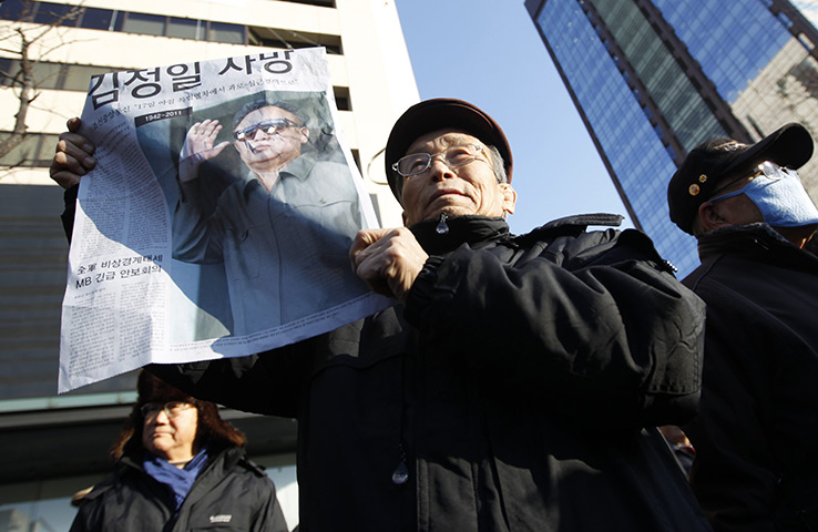 Reaction to Kim Jong il: An elderly South Korean man from an anti-North Korean group holds a paper