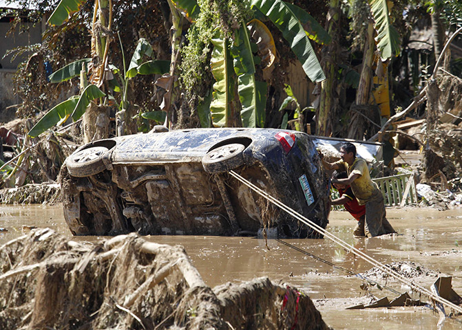 Philippines flooding: Residents retrieve a car which was washed away in the flash flooding
