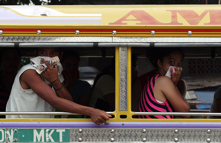 Philippines flooding: Locals cover their noses as they look at dead bodies of storm victims
