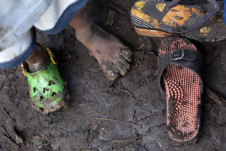 Philippines flooding: John Loyd Lagrillo, 4, shows his foot in front of his damaged house