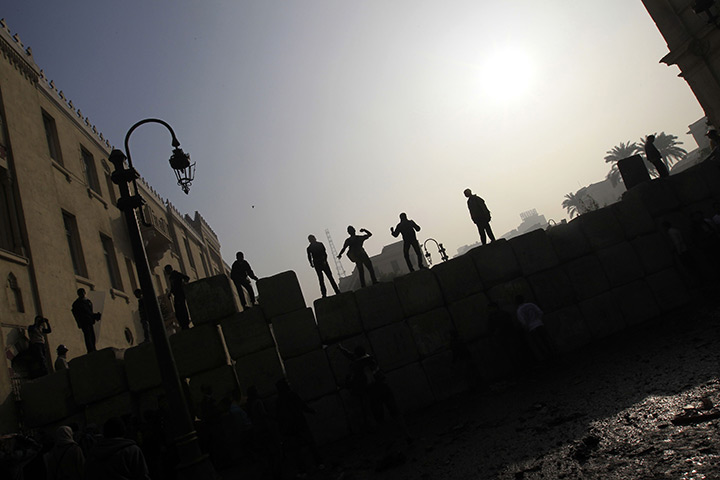 24 hours: Cairo, Egypt: Egyptian youth stand on a wall 