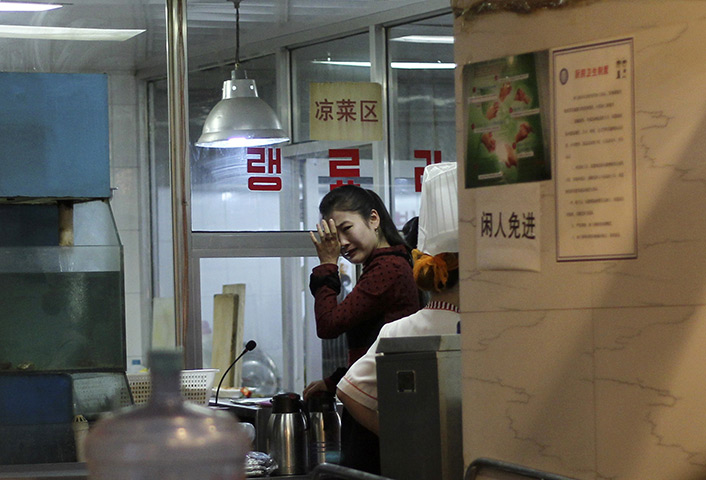 24 hours: Beijing, China: A waitress cries after hearing of the death of Kim Jong-il