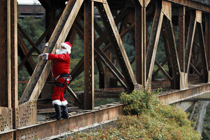 24 hours: Guatemala City: A firefighter dressed as Santa Claus rappels down a bridge