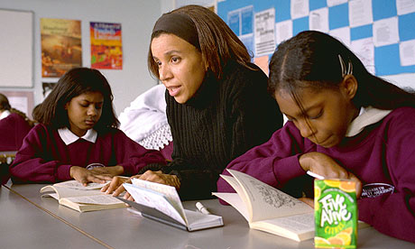 Woman helping schoolchildren read
