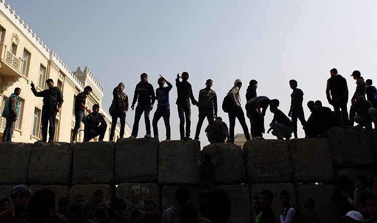 24 hours in pictures: Egyptian protesters stand on top of cement blocks forming a barrier