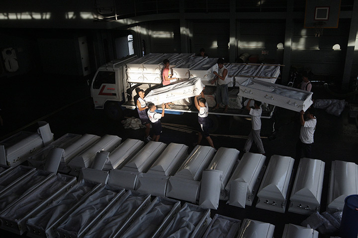 24 hours in pictures: Philippine Navy personnel and Filipino workers arrange donated caskets