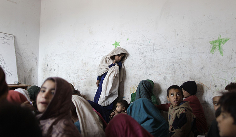 24 hours in pictures: Afghan refugee children attend a school in a slum in Pakistan