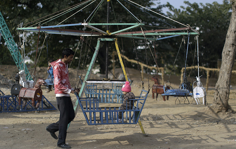 24 hours in pictures: A Pakistani child enjoys a ride, in a Christian neighborhood