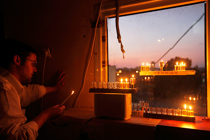 Hanukkah: A Jewish seminary student lights a candle for Hanukkah in Ashdod, Israel