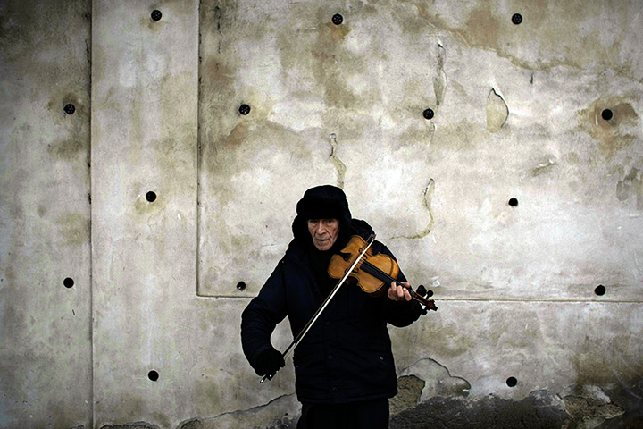 vaclav havel funeral: A violinist plays on a street