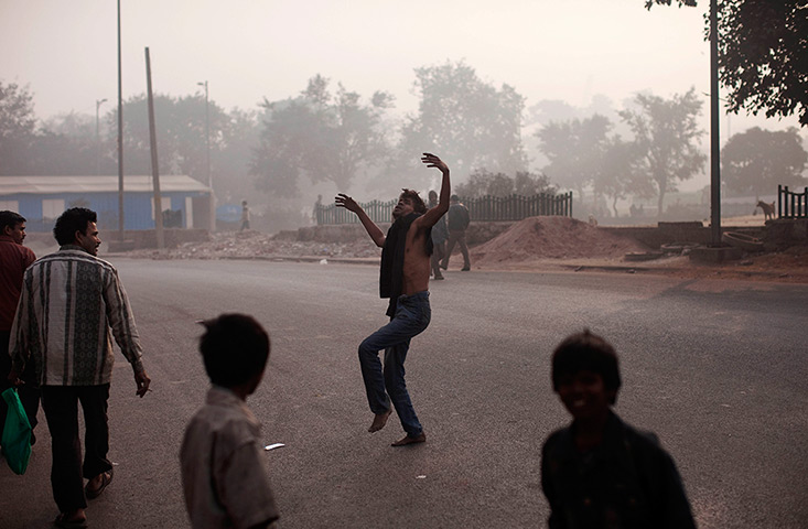 24 hours in pictures: A homeless Indian dances on a street in New Delhi, India