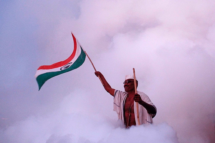 24 hours in pictures: A supporter of Anna Hazare waves an Indian national flag