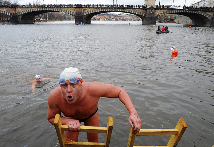 24 hours in pictures: A swimmer reacts as he climbs a ladder to leave the Vltava river