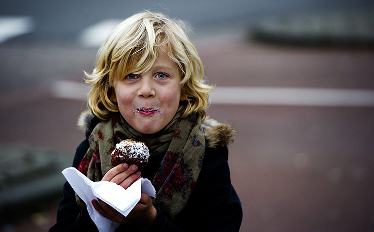 24 hours in pictures: Rotterdam, Netherlands: A child eats a 'oliebol' (Dutch donut)