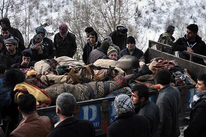 24 hours in pictures: Uludere, Turkey: Locals gather in front of a truck carrying bodies