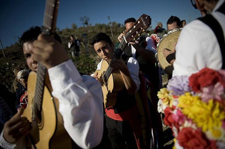 24 hours in pictures: Malaga, Spain: A man in traditional costume tunes his guitar
