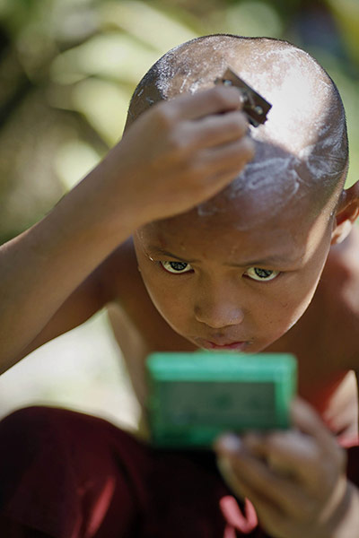 24 Hours: a Buddhist novice monk shaves his head at a monastery in central Yangon
