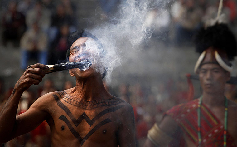 24 Hours: a Naga fire eater bites a burning stick at the Hornbill festival