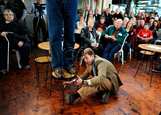 Iowa campaigning: A campaign staff member holds a chair as Mitt Romney speaks in Mason City