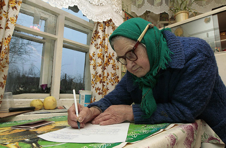russia elections: A woman fills an voting form in her house in Gryaz 