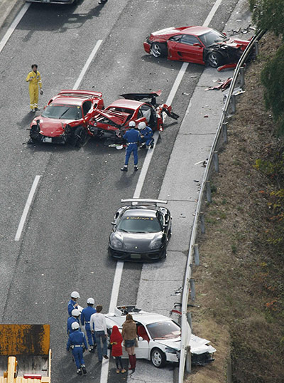 Japan car pile-up: Police officers investigate wrecked luxury cars