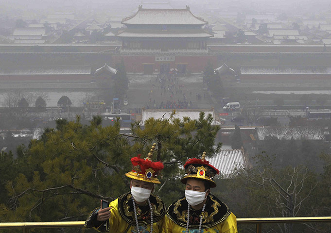 24 hours in pictures: Beijing, China: Tourists in costumes overlooking the Forbidden City