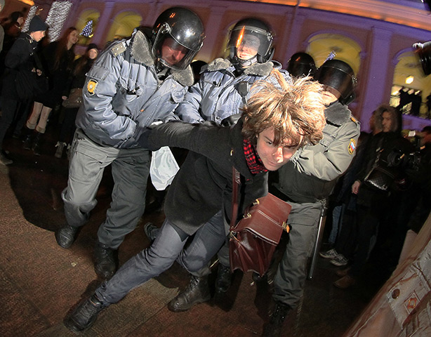 Russia protests: Police officers detain an opposition activist during a protest
