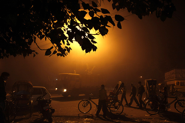 24 hours in pictures: Rickshaw drivers wait for customers on a foggy street corner in Allahabad
