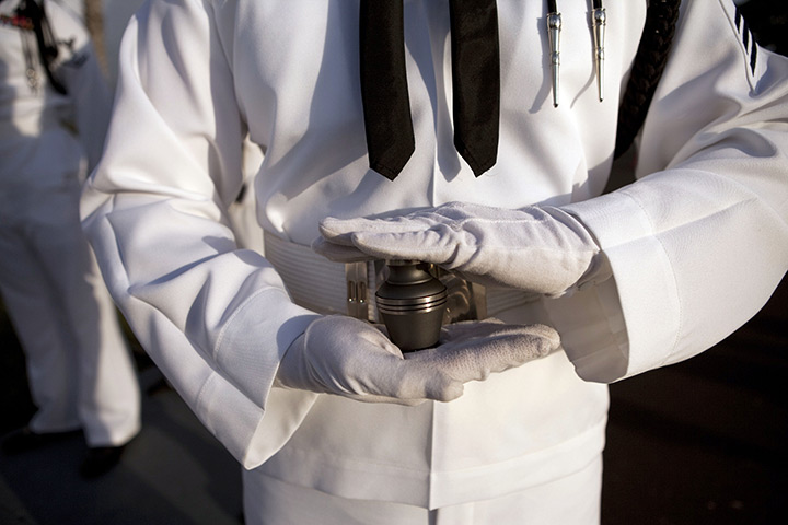 24 hours in pictures: A sailor holds an urn with the ashes of Pearl Harbor survivor Lee Soucy