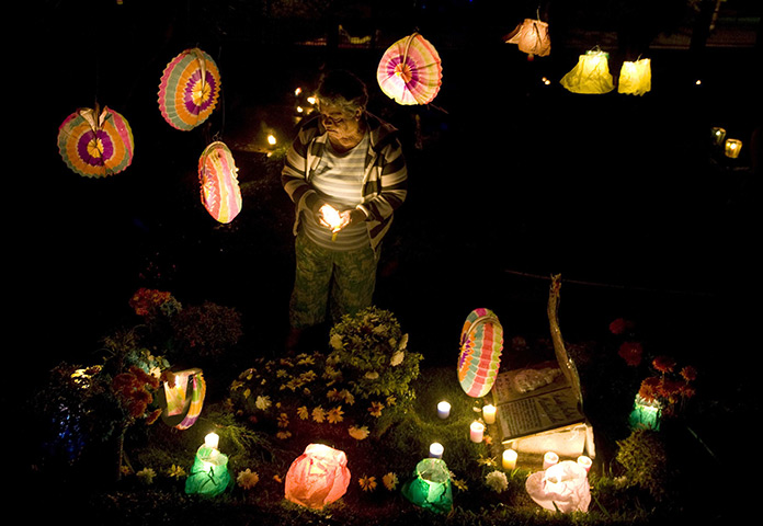 24 hours in pictures: A woman decorates the grave of a relative in Columbia