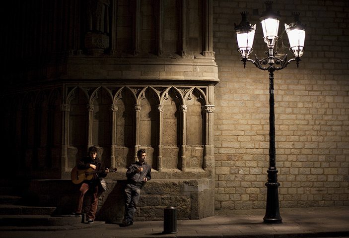 24 hours in pictures: Two street musicians make a break next to a church in Barcelona city
