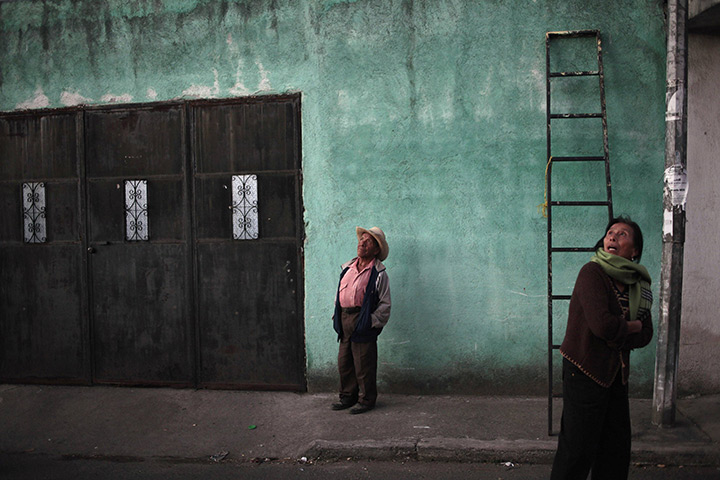 24 hours in pictures: People look at a replica of a devil during a 