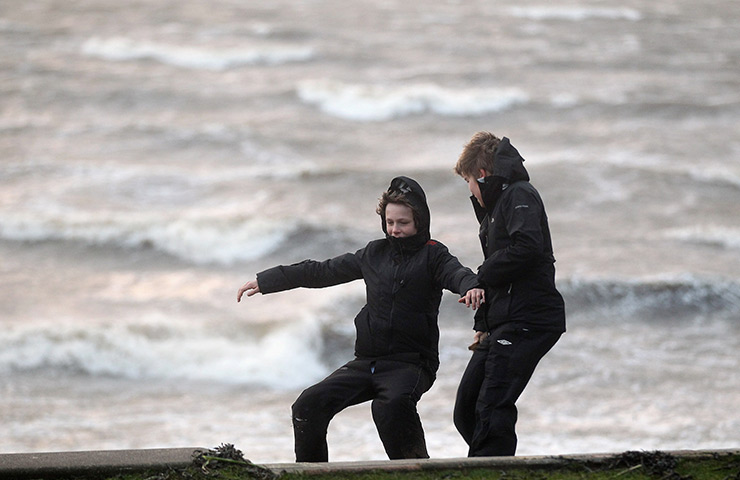 UK weather: Two boys are blown by a gust of wind in Helensburgh