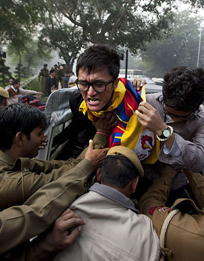 24 hours in pictures: New Delhi, India: Policemen detain an exile Tibetan during a protest rally